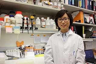 Female doctor with glasses standing in a lab