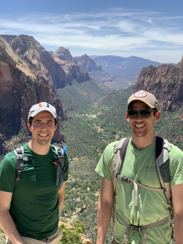 Two residents hiking with scenery in the background.