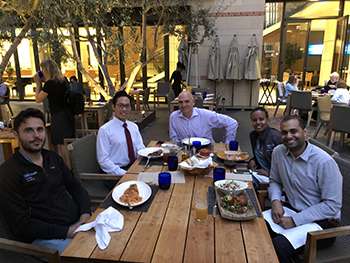 Fellows outside eating at a table