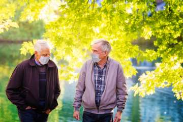 two elderly men with masks in the park