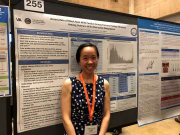 Fellow Nancy in front of her research presentation
