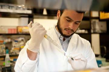 Student using pipette to fill tube