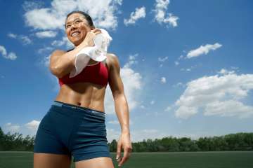 Woman using a towel to wipe off sweat