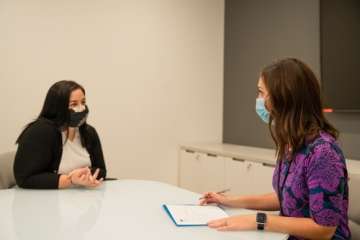 Two genetic counselors having a discussion at a desk