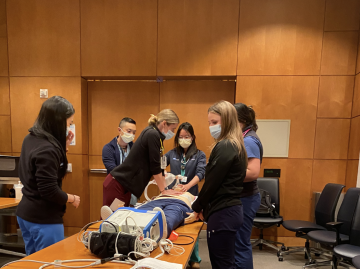 patient simulation in a conference room with a doctor practicing chest compression