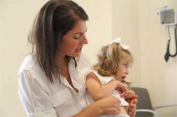 doctor holding child with cerebral palsy