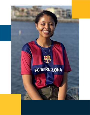 Resident Enat Arega in front of a body of water while wearing a jersey