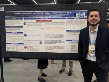 Jose Luis Lopez, MD standing beside poster.
