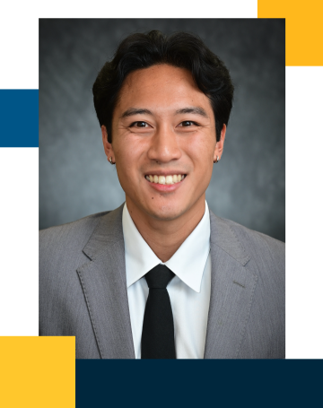 Smiling professional headshot of person in gray suit and black tie