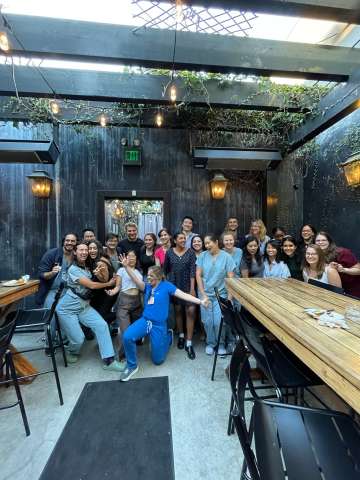 A large group of Internal Medicine Residents posing at a corner of a restaurant