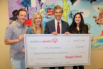 Staff holding large donation check from Hopeful Hearts for $20,000