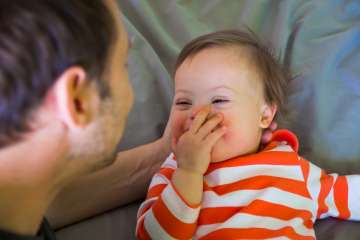 Father playing with his child on a bed