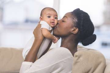 Mother holding and kissing her baby