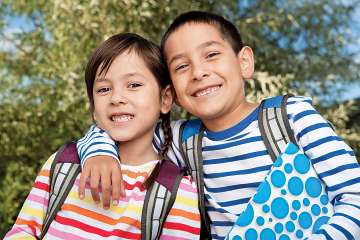 two children smiling outside