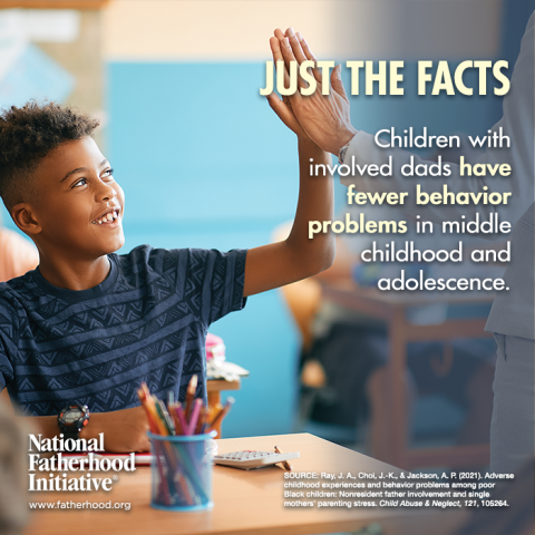 A young boy raising his hand in a classroom