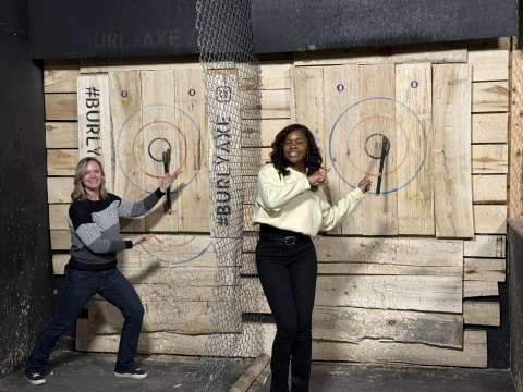 Two women pointing at target boards