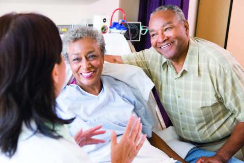 A woman and her husband speaking with a doctor