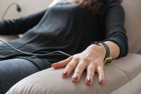 Woman sitting on couch checking biofeedback