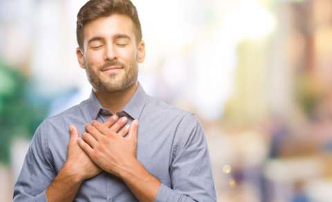 Man with hands pressed against chest relaxing