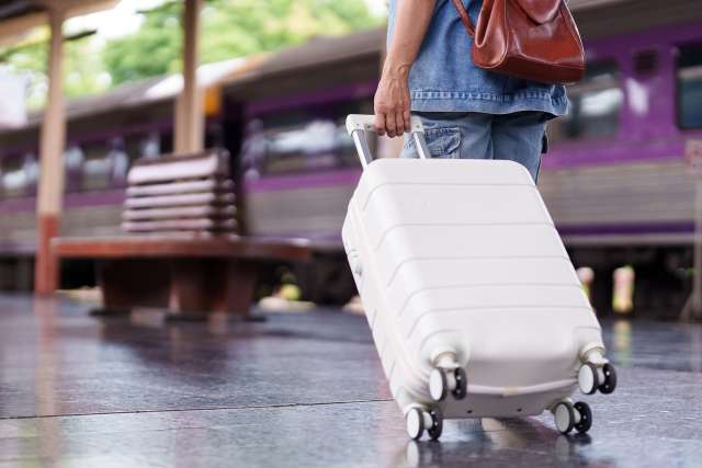 Man walking with white suitcase