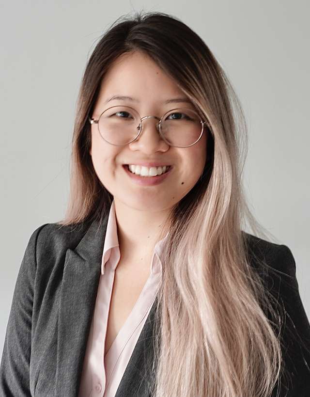 Betty Wong wearing a business suit, with long, light brown hair, against a neutral background.