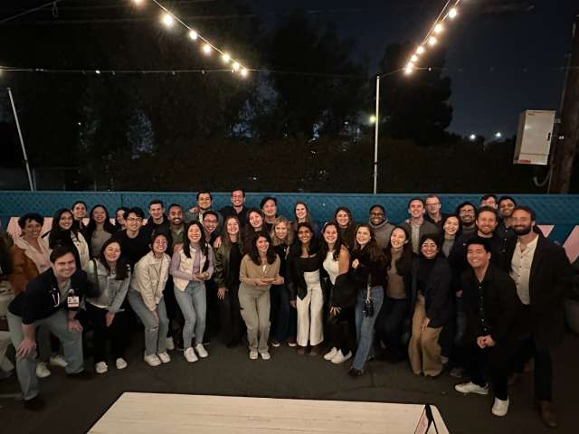 A large group of Internal Medicine Residents posing at an outdoor patio at night