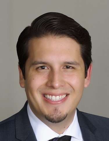 Headshot of Christopher Mayorga wearing a suit.
