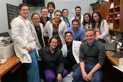 A group of doctors smiling and facing the camera in an office setting