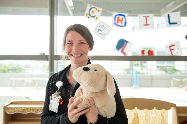 Woman smiling holding stuffed animal