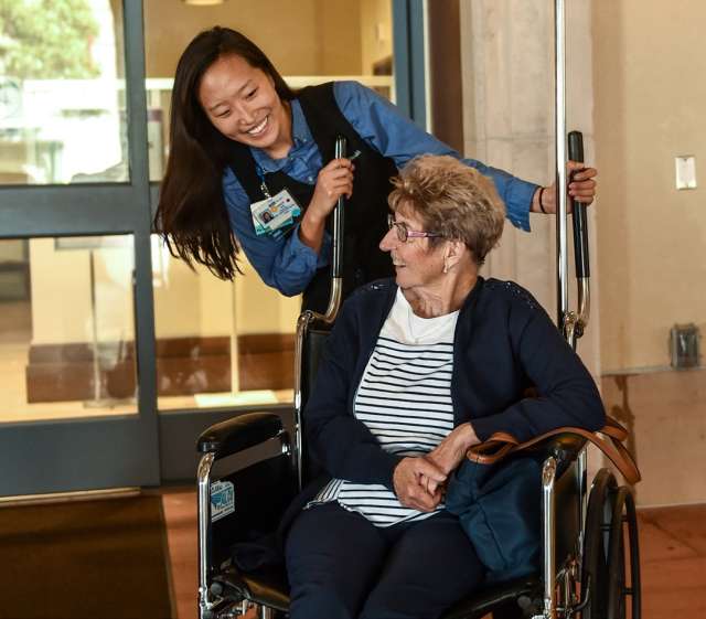 Nurse pushing woman in a wheelchair