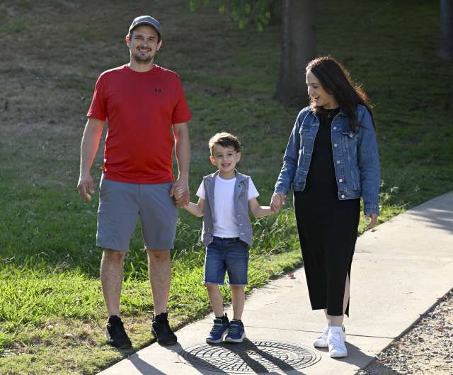 Jakob Guziak walks with his parents