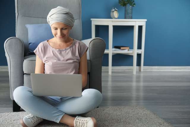 woman with cancer on the computer smiling