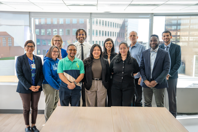 Group photo of a team standing together in an office setting.