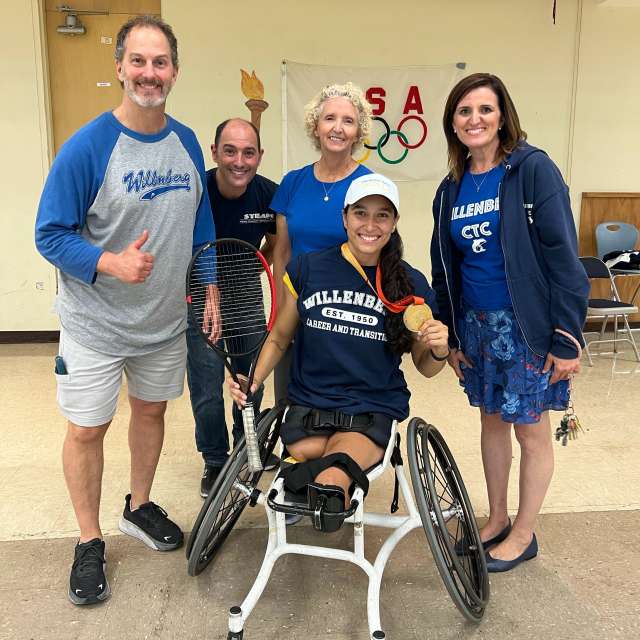 Teachers and administrators pose with Paralympian