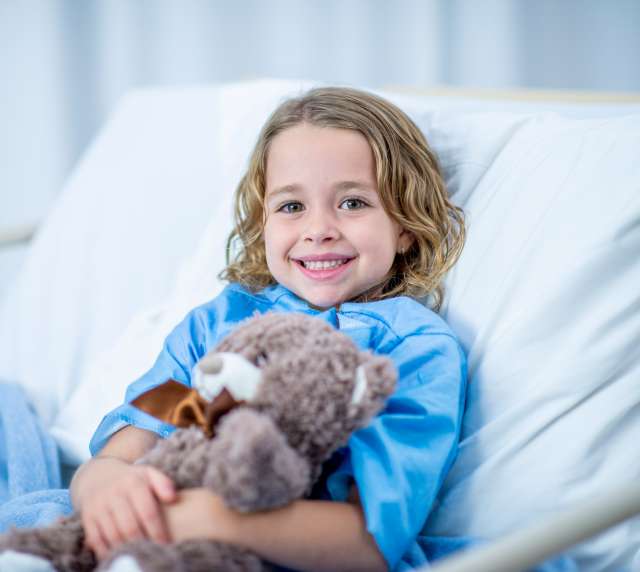 Child in hospital bed smiling