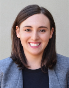A smiling woman with dark hair and a blue jacket.