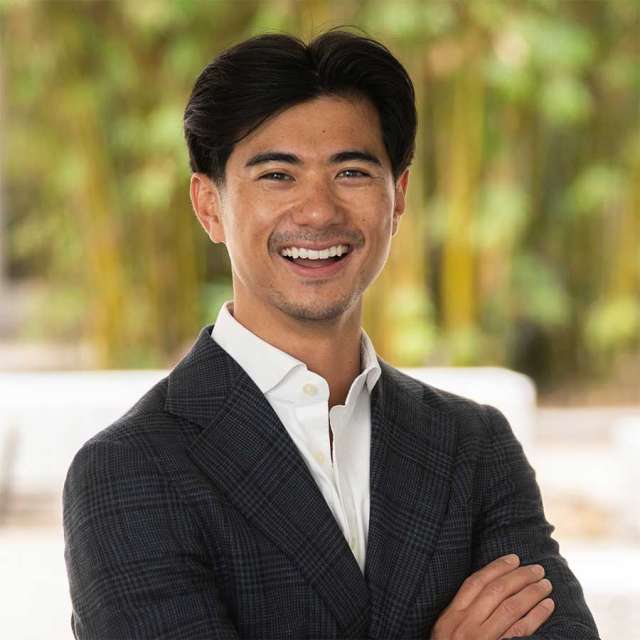 Kekoa Taparra MD smiling, in a professional headshot with arms crossed.