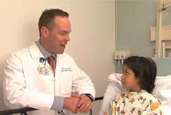 Doctor speaking to child patient bed side