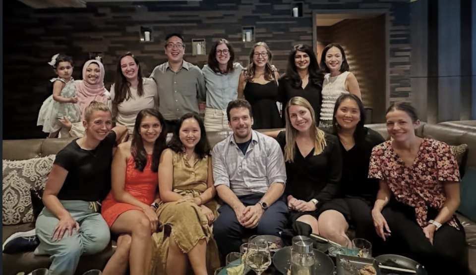 Group photo of a diverse group of people seated and standing together, smiling.