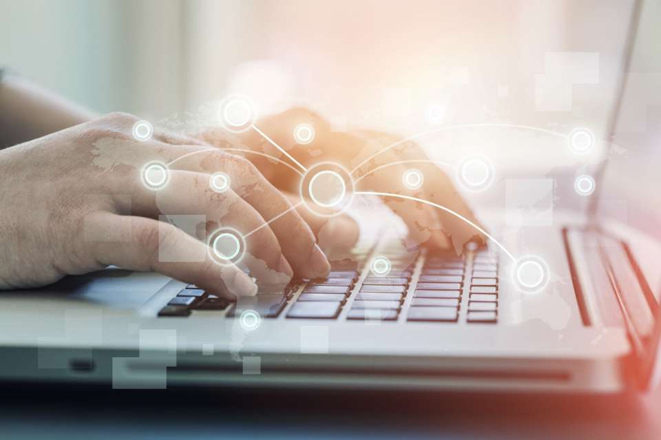 Hands typing at a laptop