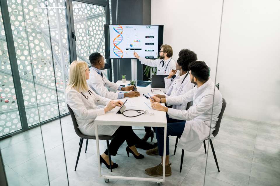 Doctors discussing a presentation in hospital conference room