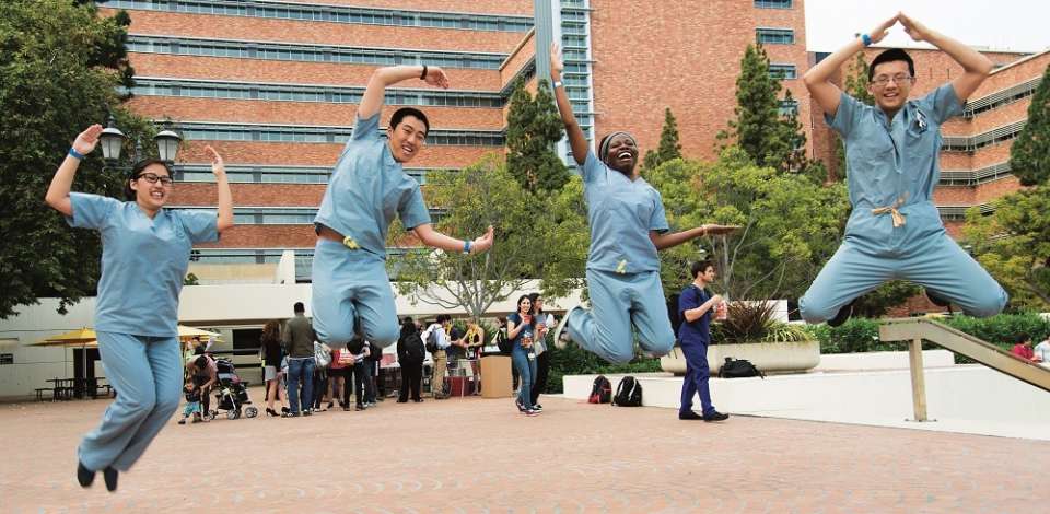 Students jumping in air and forming "UCLA" letters with arms