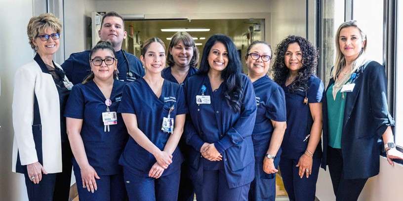 Coleen Wilson with nurses and leaders from 4 West, all smiling and standing together.