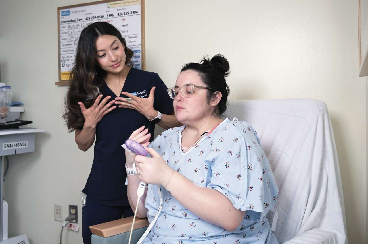 Nurse helping a patient in a hospital setting, both engaged in conversation.