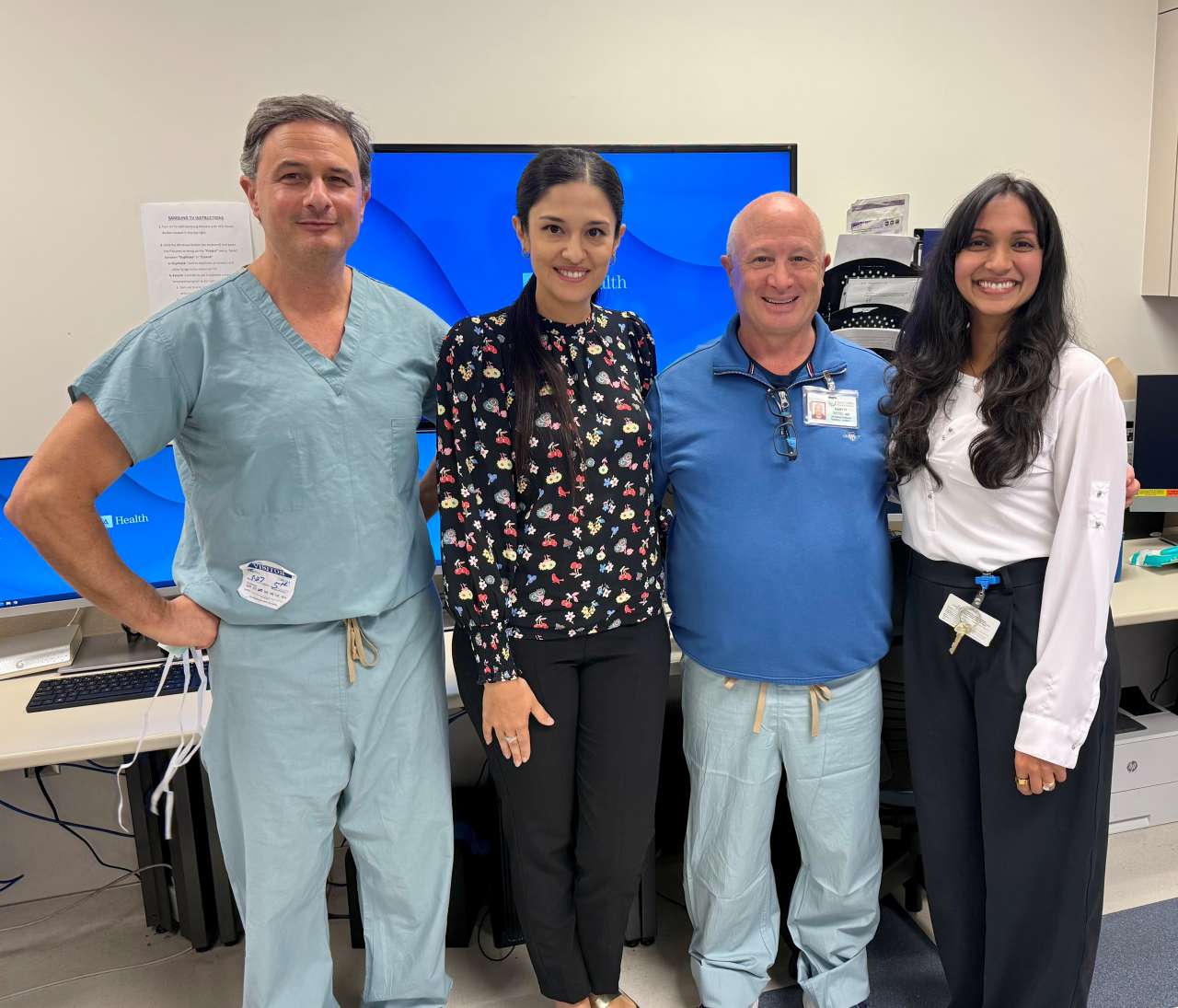 A medical team poses in an office. From left to right: Dr. Gregory Perens, Dr. Gigi Ganieva. Dr. Gary Satou, and Dr. Sonia Voleti.