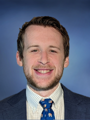 Dr. Jacob Klickstein in a suit smiling at the camera