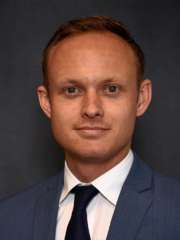 headshot of Dr. Bennet Shaw in a blue suit