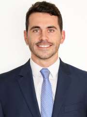 Doctor Conor Fowler in a blue suit and blue tie in front of a white wall