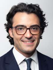 Headshot of Sam Olson in black suit