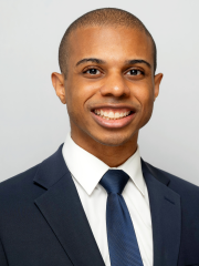 Dr. Paul Lewis in a suit smiling at the camera